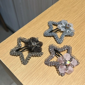 Vue détaillée de barrettes étoilées avec fleurs en résille perlées et strass colorés