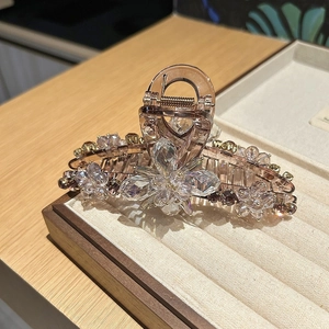 Detail of flower hair claw clip with champagne crystals and intricate beaded petals
