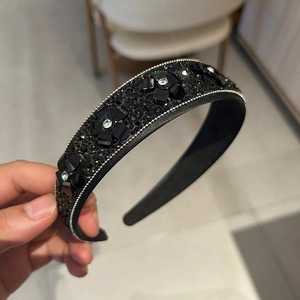 Détail d'un serre-tête fleurs en cristal noir avec strass et perles travaillées