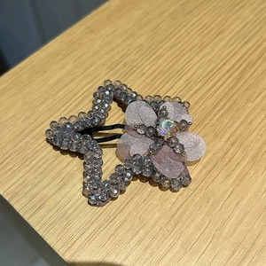 Vue détaillée d'une pince à cheveux en étoile avec perles bleues et fleur en tissu
