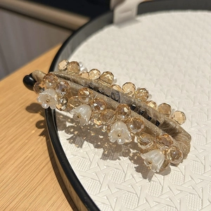 Détail de la pince banane champignon perlée avec pendentif fleur de muguet élégant