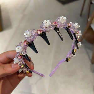 Detail of purple beaded headband with floral accents and integrated hair styling clips
