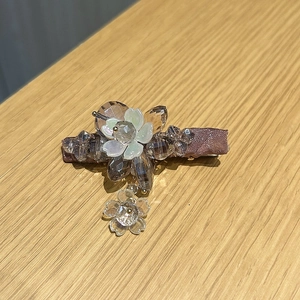 Detail view of the floral crystal hair clip with light brown beads and shell-like petals
