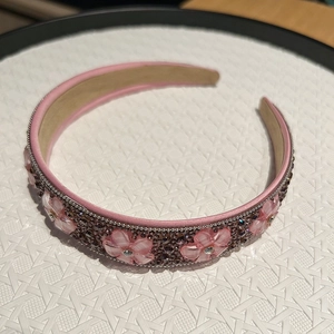 Gros plan sur le serre-tête fleurs en cristal rose avec strass brillants et satin