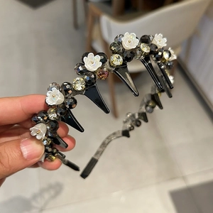 Detailed view of the double-layer crystal headband featuring white flowers and styling clips