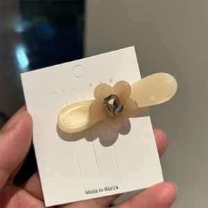 Pince à cheveux fleur en acétate chic avec strass gris sur base crème type bec de canard