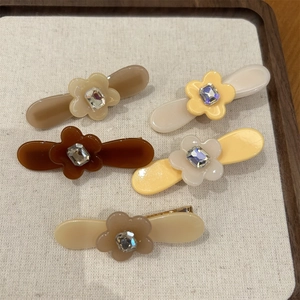 Lot détaillé de 5 barrettes à fleurs en acétate avec centre en cristal