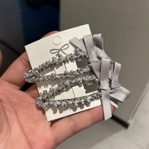 Lot de quatre barrettes à perles argentées avec nœuds en satin gris sur carte blanche