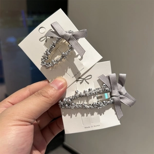 Set de pinces à cheveux à perles argentées et nœuds gris sur carte de support