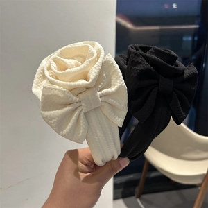 Close-up of elegant wide fabric headbands featuring large cream and black 3D fabric roses