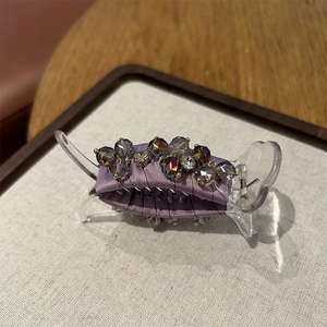 Detail view of purple satin hair claw clip with sparkling crystals and rhinestones