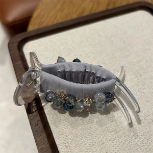 Detailed view of luxury large hair claw clip with colorful crystal beads and satin fabric