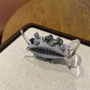 Detail of crystal beads and light grey fabric wrap on a premium hair claw clip