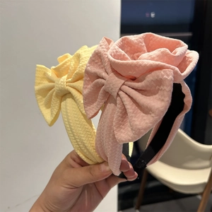 Detail of yellow and pink fabric headbands featuring large layered bubble texture bows