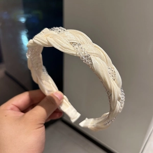 Detail of cream braided headband with crystal beads and non-slip inner teeth structure