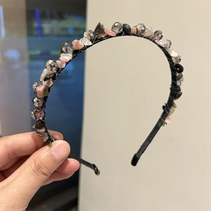 Detailed close-up of handmade black headband with multicolor crystals and natural stones