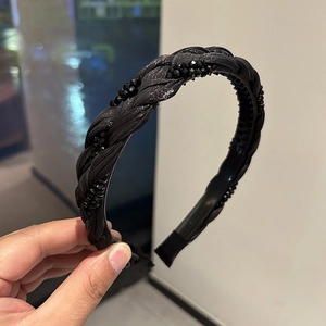 Detailed close-up of a black braided headband with shimmering crystal accents and non-slip teeth