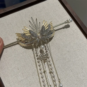 Detail of golden wing hair pin with flowing tassels and white pearls in retro Chinese style