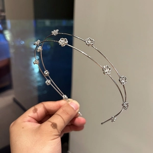 Close-up of double-layered silver headband with delicate rhinestone flowers for women