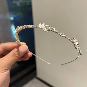 Détail de serre-tête floral doré avec pétales roses et pierres de zircon brillantes