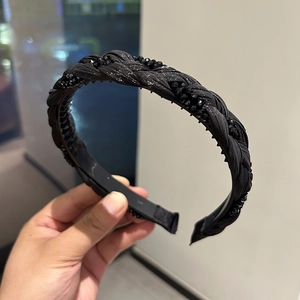 Close-up of a black braided headband with shimmering crystal beads and anti-slip teeth