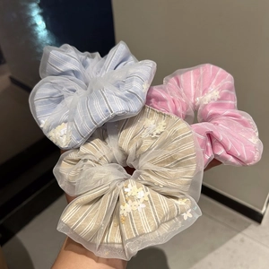 Detail of three organza scrunchies with stripe fabric and delicate floral sequins