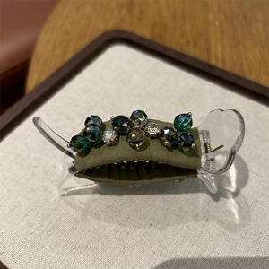 Detailed view of large olive green crystal hair claw clip with elegant bead decorations