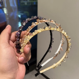 Detailed view of handmade crystal headbands in purple, pink, and yellow gemstones