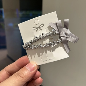 Pinza para el pelo con cuentas plateadas y lazo de satén gris en tarjeta premium