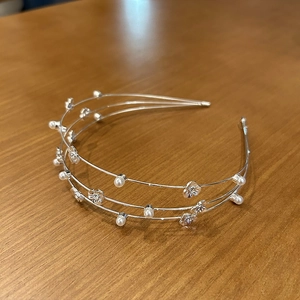 Detail of silver triple-wire headband with white pearls and delicate floral ornaments