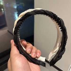Detail of black and white braided headband with non-slip teeth and bead accents