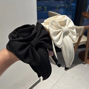 Detailed view of handmade bow headband featuring waffle textured fabric in black and white