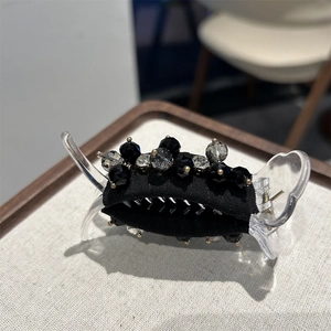 Close-up of elegant crystal hair claw with black fabric and multifaceted beads