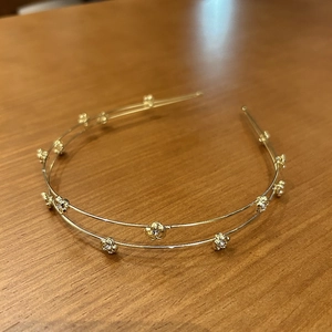 Detail of a thin double-layered gold floral headband with delicate sparkling accents