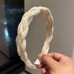 Close-up of cream braided headband with clear crystal beads and silk texture