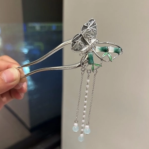Dettaglio di forcina per capelli a farfalla in bambù argento con lunghe nappe di perle