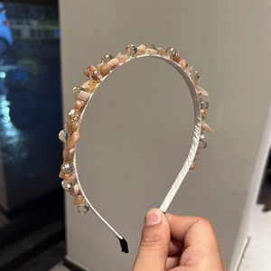 Close-up of handmade luxury headband with orange crystals and shiny yellow rhinestones
