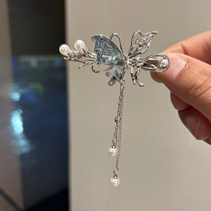 Dettaglio di un fermaglio per capelli a farfalla argento con perle e nappe pendenti