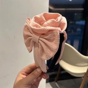 Detail of pink floral headband featuring large 3D flowers and textured crinkle fabric