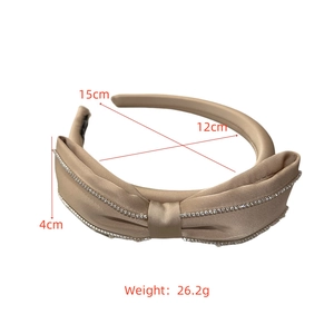 Detail showing satin bow headband dimensions of 15cm width and rhinestone edging