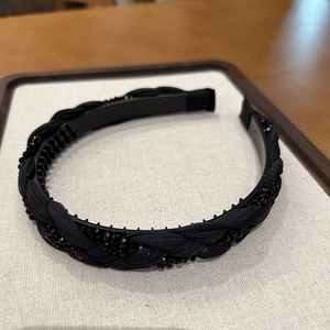 Detail of black braided headband with faceted beads and non-slip inner teeth display