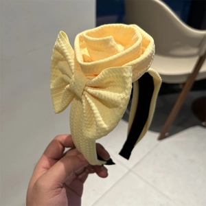 Close-up of yellow waffle fabric headband featuring 3D rose and bow details