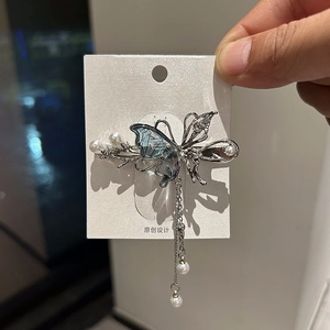 Fermaglio per capelli a farfalla argento con texture blu, perle bianche e nappe