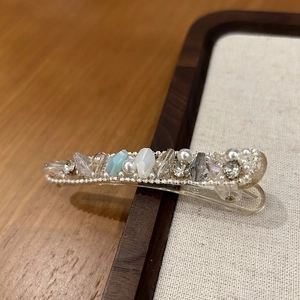 Macro detail of handmade duckbill hair clip with crystals, pearls and intricate beadwork