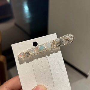 Elegant hair clip with pearls, clear crystals, and light blue teardrop stones on alloy base