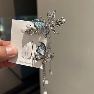 Dettaglio molletta a farfalla argentata con ali sfumate blu e frange di perle lucide