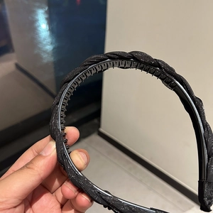 Detail of black braided headband with shimmering finish and non-slip inner teeth grip