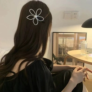 Pince à cheveux fleur en perles de style français sur cheveux bruns pour un look chic