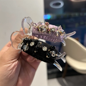 Detailed view of hair claws with elegant purple and black satin fabric and crystal beads