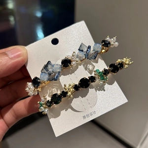 Detail of handmade crystal and pearl hair clips with gold alloy base on display card